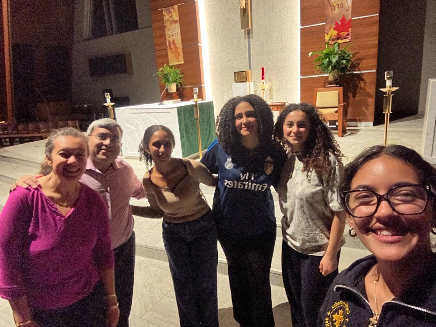 WVU COYA students and servants smiling together in the church