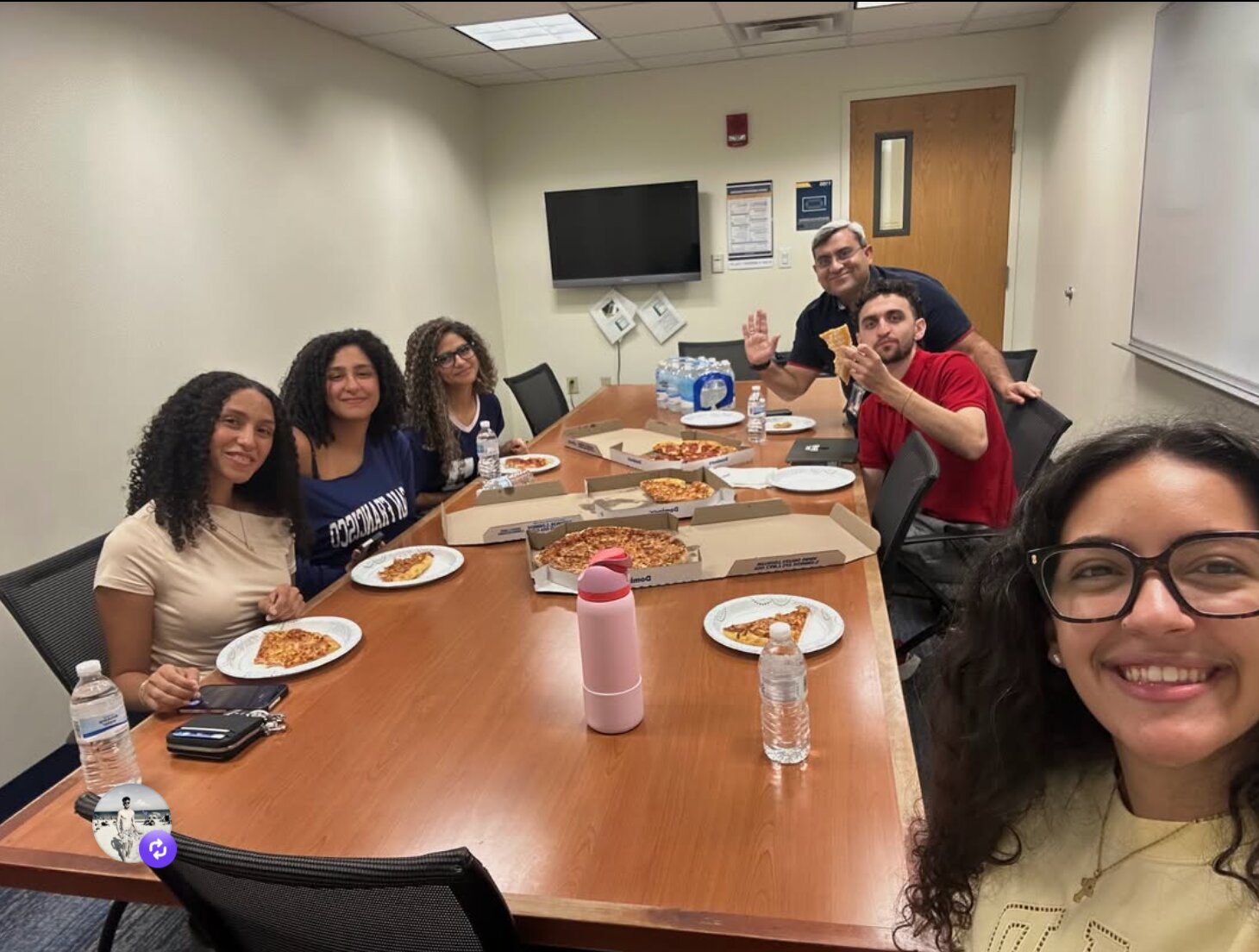 WVU COYA students sharing pizza around a table